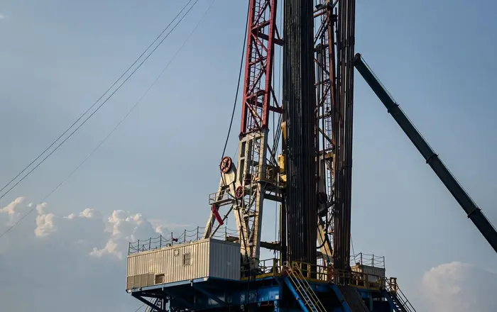 A land drilling rig and heavy equipment at an oil and gas worksite