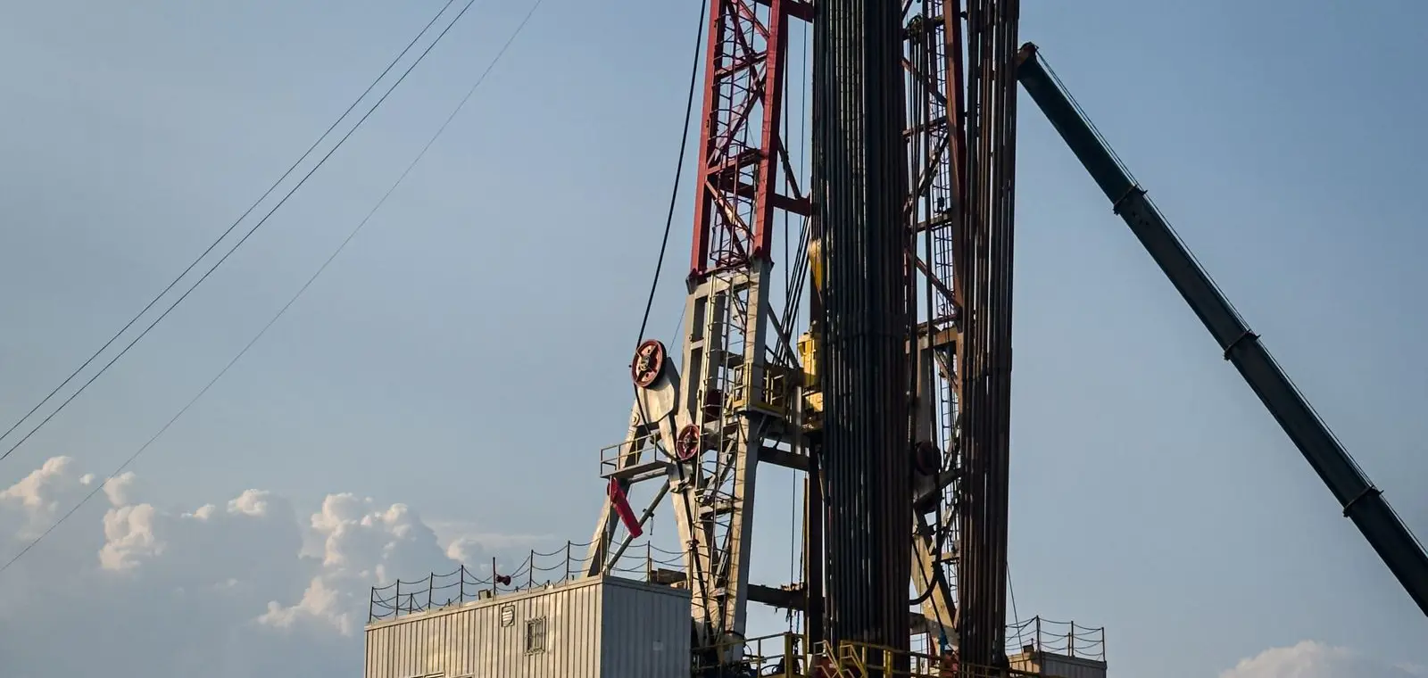 A land drilling rig and heavy equipment at an oil and gas worksite