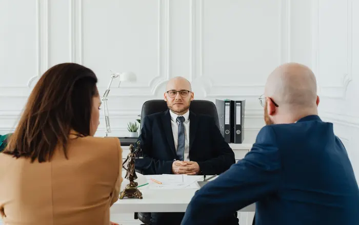 A personal-injury attorney consulting with clients across an office desk