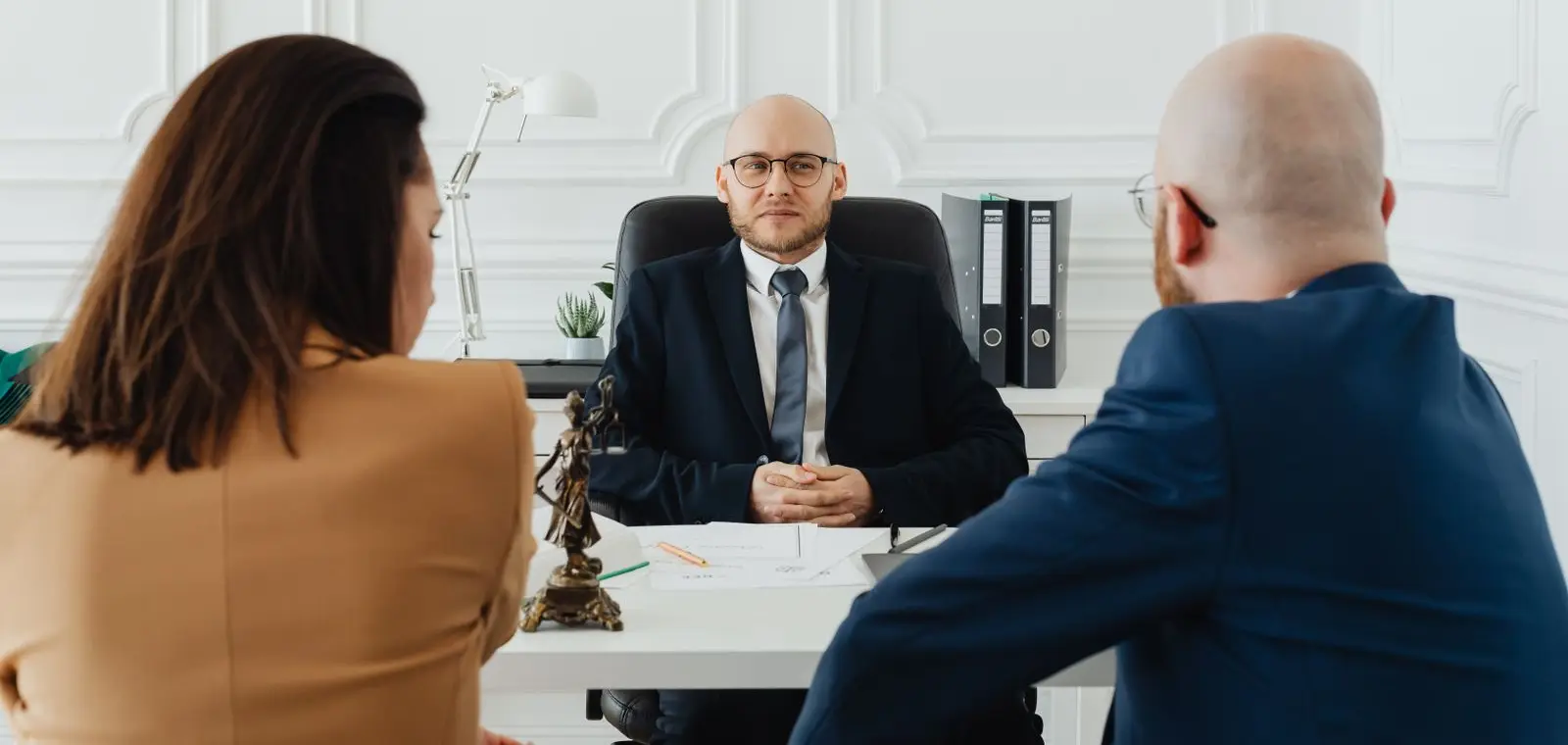 A personal-injury attorney consulting with clients across an office desk