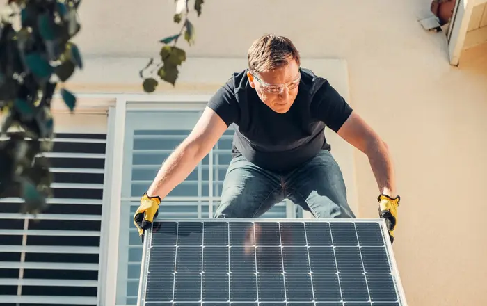 A technician installing a solar panel on a residential rooftop