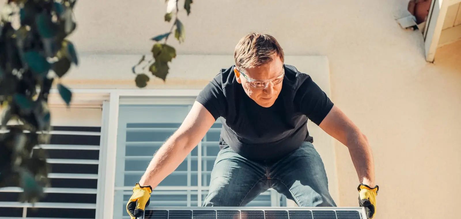 A technician installing a solar panel on a residential rooftop